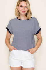woman wearing a navy and white striped short sleeve top with rolled cuffs and white shorts