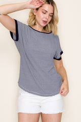 woman wearing a navy and white striped short sleeve top with contrasting cuffs and white denim shorts