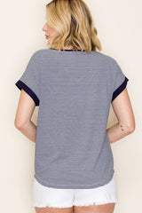woman wearing a navy and white striped short sleeve top with contrasting dark sleeves and light denim shorts