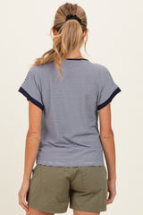 woman wearing a navy and white striped maternity top, viewed from the back with casual green shorts