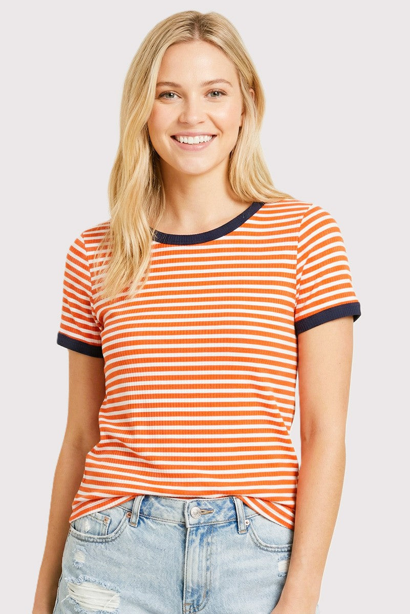 woman wearing an orange and white striped t-shirt with navy blue trim and light blue distressed jeans