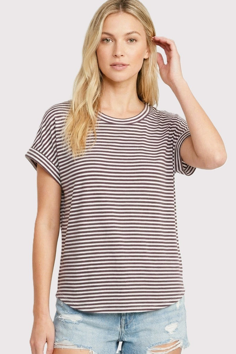 woman wearing a striped short sleeve t-shirt in brown and white with rolled cuffs and denim shorts