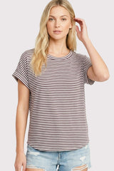 woman wearing a striped short sleeve t-shirt in brown and white with rolled cuffs and denim shorts