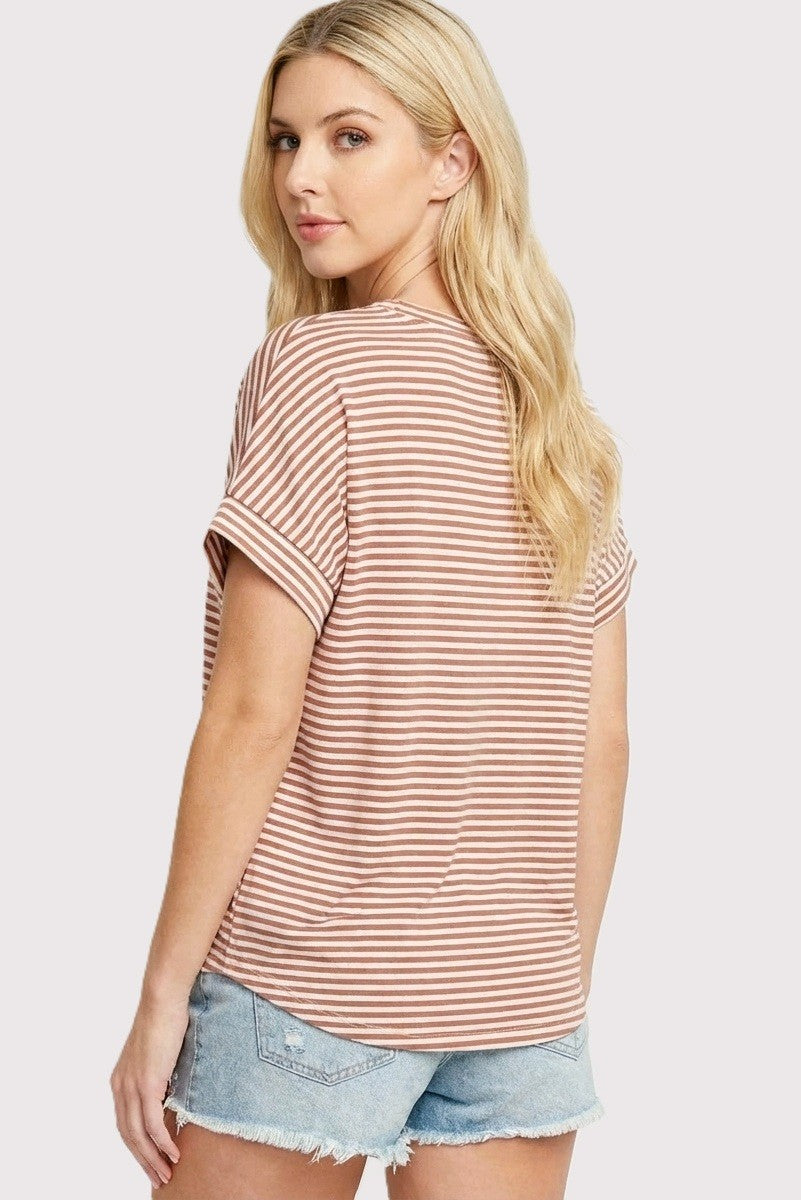 woman wearing a brown and white striped short sleeve top with a relaxed fit and rolled sleeves, paired with denim shorts