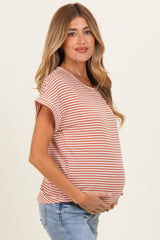 woman wearing a rust and white striped maternity top and holding her baby bump