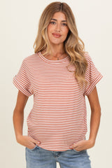 woman wearing a rust and cream striped maternity top with rolled sleeves and casual fit