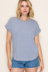 woman wearing a navy and white striped short sleeve top with rolled cuffs and styled with denim shorts