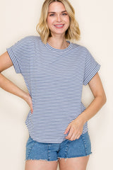 woman wearing a navy and white striped short sleeve top with rolled cuffs and denim shorts