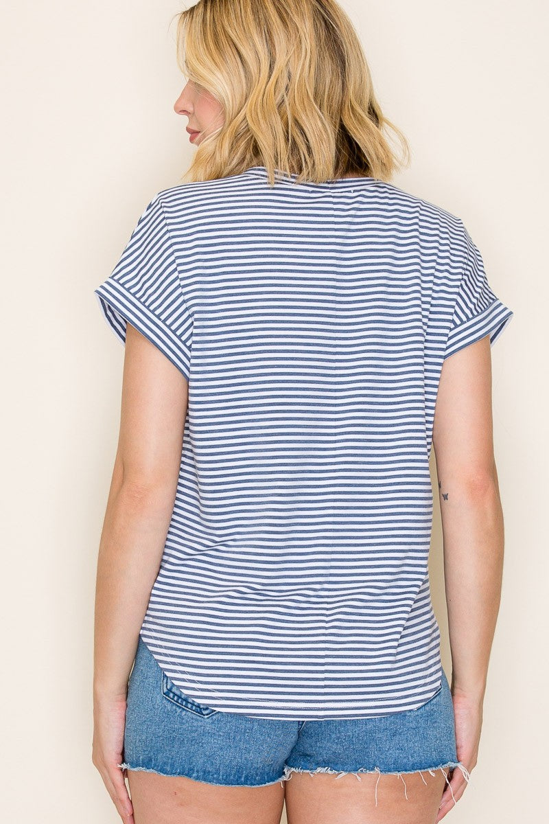 woman wearing a navy and white striped short sleeve top with rolled cuffs and denim shorts