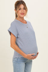 woman wearing a navy and white striped maternity top, smiling and holding her baby bump