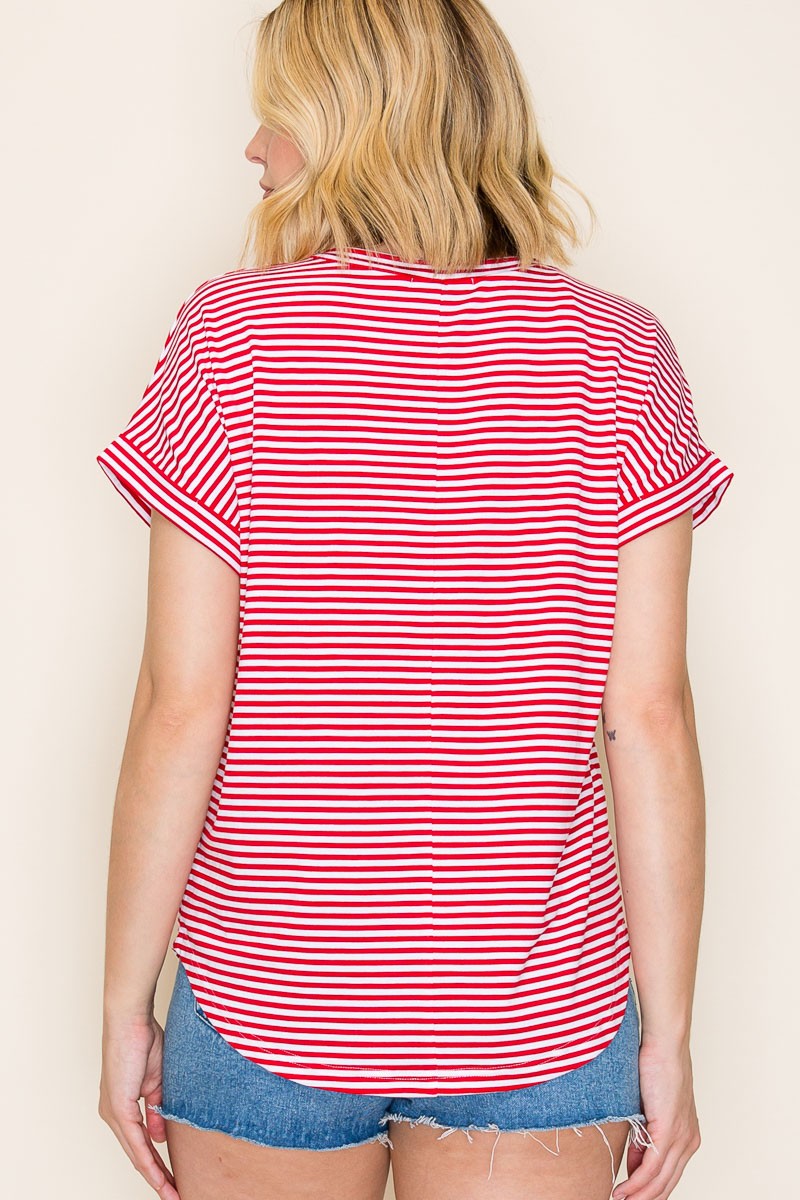 woman wearing a red and white striped short sleeve top with rolled sleeves and a curved hem, viewed from the back