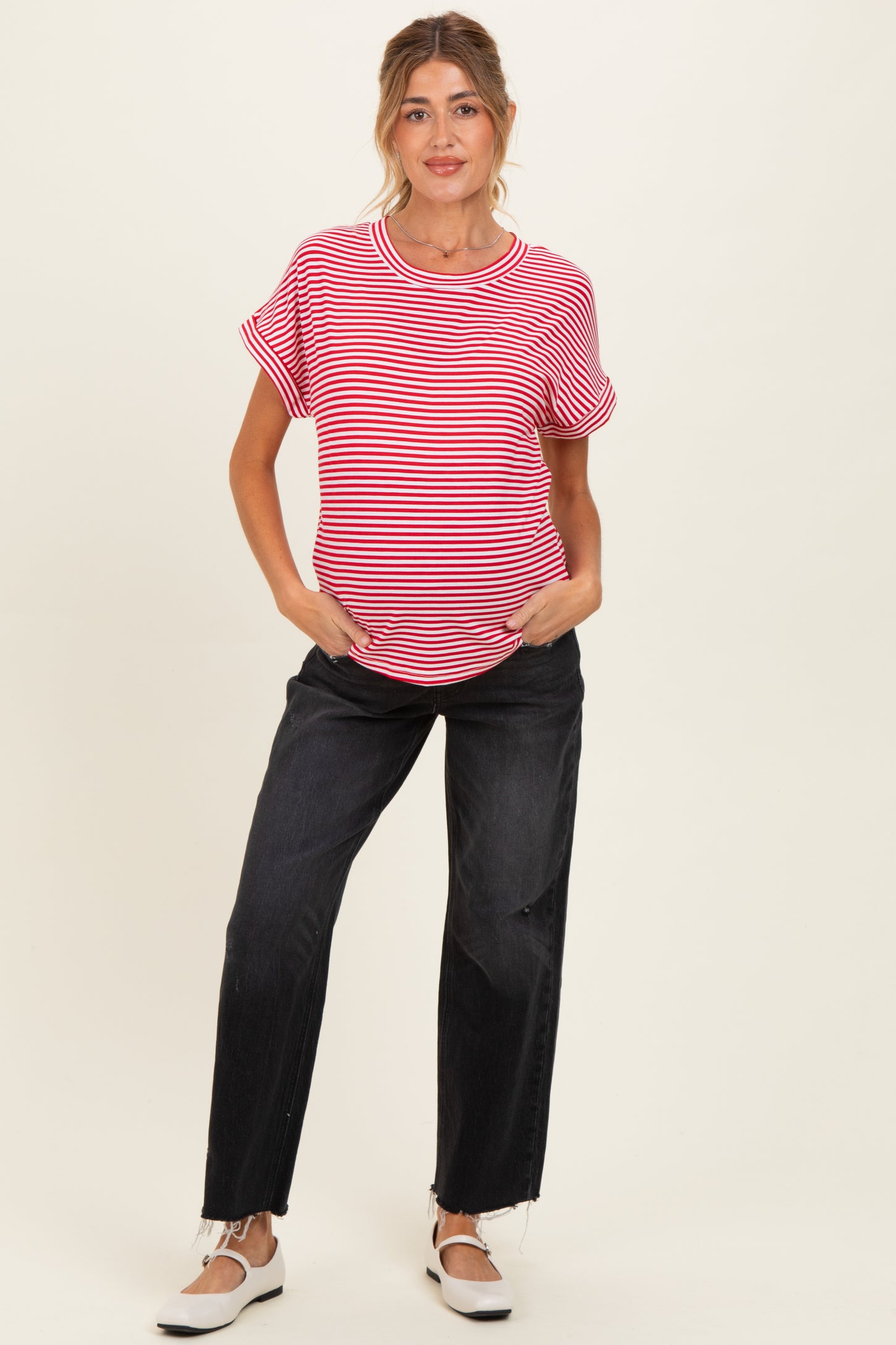 woman wearing a red and white striped maternity t-shirt with rolled sleeves and black maternity jeans, showing baby bump