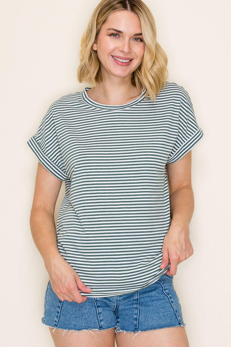 woman wearing a light green and white striped short sleeve t-shirt with rolled sleeves and denim shorts
