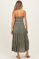 woman wearing a green maternity maxi dress with a smocked bodice and tiered skirt, viewed from the back