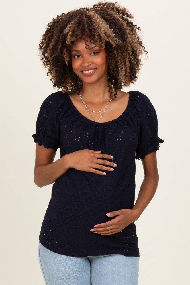 woman wearing a navy blue maternity blouse with ruffled sleeves and a visible baby bump