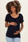 woman wearing a navy blue maternity blouse with ruffled sleeves and a visible baby bump