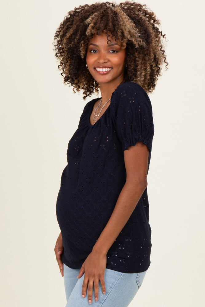 woman wearing a navy blue maternity top with short puff sleeves and a baby bump visible