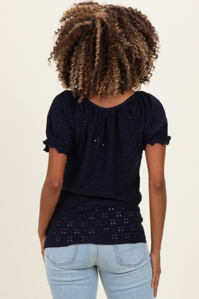 woman wearing a navy blue short sleeve maternity top with a scalloped neckline and eyelet details, showing her back
