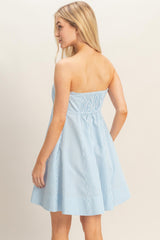 woman wearing a blue and white striped strapless sundress with a fitted bodice and flared skirt