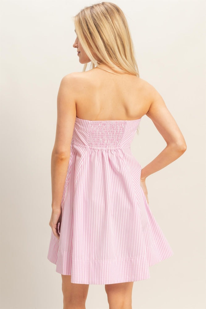 woman wearing a pink and white striped strapless dress with a smocked back and flared skirt