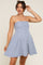 woman wearing a navy and white striped strapless maternity dress with a flared skirt and visible baby bump