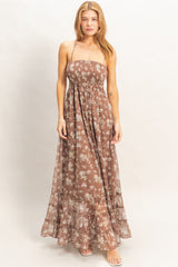 woman wearing a brown floral maxi dress with a smocked bodice and ruffle hem