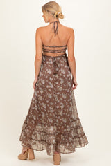 woman wearing a brown floral maternity maxi dress with a halter neck and tiered ruffle hem