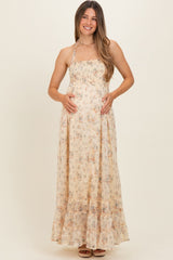 woman wearing a floral strapless maternity maxi dress and holding her baby bump