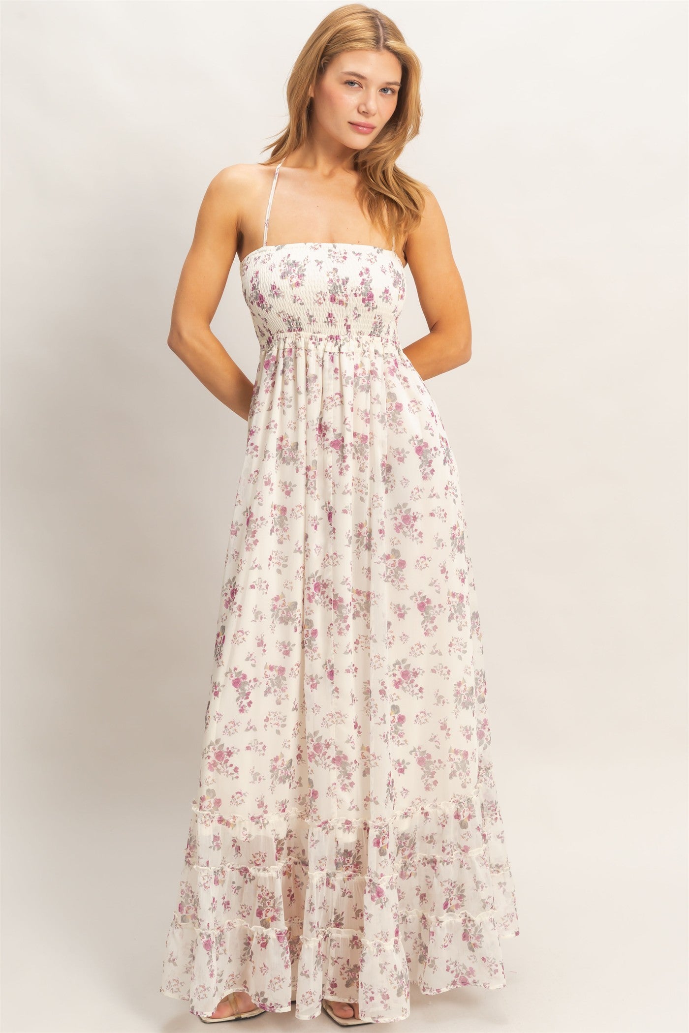 woman wearing a white floral maxi dress with a smocked bodice and adjustable straps