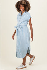 woman wearing a light blue striped maternity dress with a tie waist and short sleeves, showing her baby bump