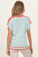 woman wearing a light blue maternity sweater with coral trim and short sleeves, viewed from the back
