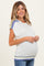 woman wearing a light gray maternity sweater with colorful stripes and holding her baby bump