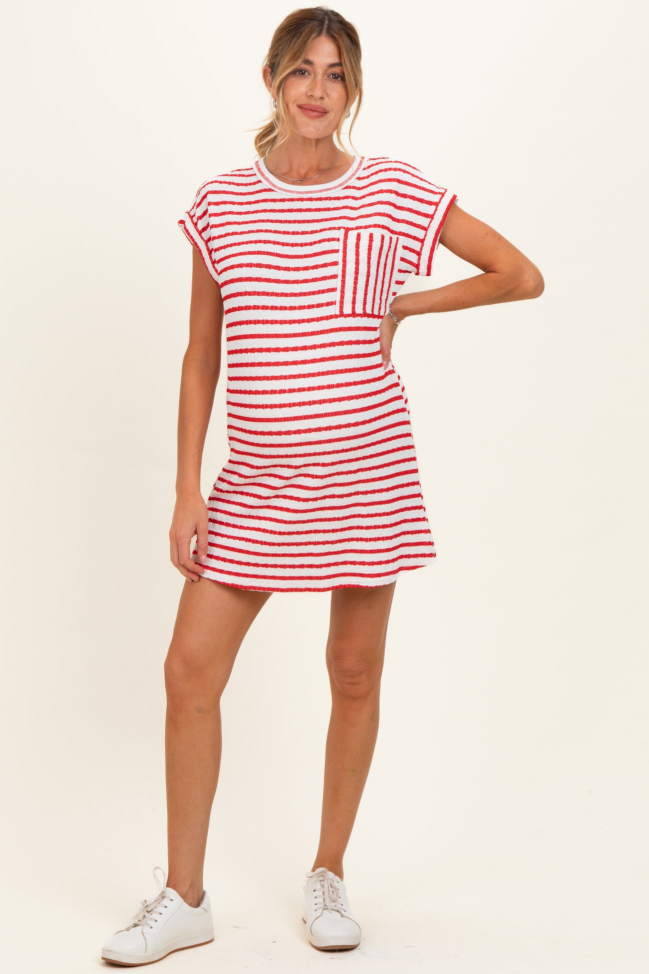 woman wearing a red and white striped maternity dress with a pocket and short sleeves