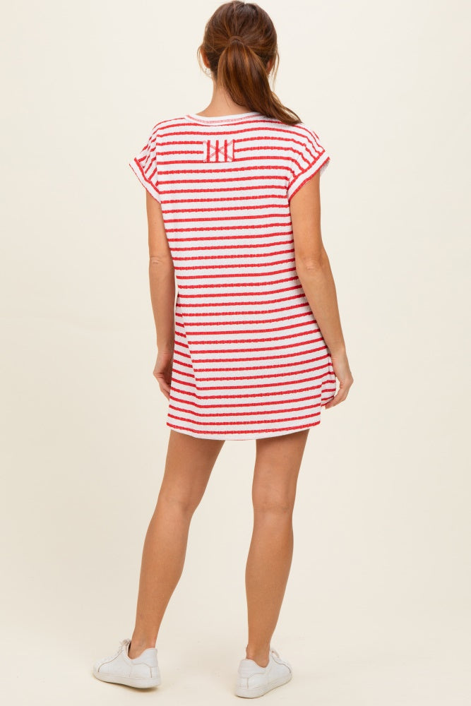 woman wearing a short red and white striped dress with short sleeves and a relaxed fit, viewed from the back