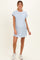 woman wearing a light blue striped maternity dress with short sleeves and a front pocket
