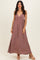woman wearing a mauve sleeveless maxi dress with a deep v-neckline and flowy silhouette