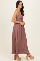 woman wearing a mauve sleeveless maxi dress with a gathered waist and strappy sandals