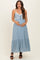 woman wearing a light blue maternity maxi dress with lace detailing and holding her baby bump