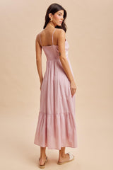 woman wearing a pink maxi dress with a smocked back and tiered hem, viewed from the back
