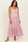 woman wearing a light pink maternity maxi dress with lace details and a baby bump visible
