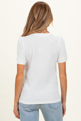 woman wearing a white short sleeve maternity top with a relaxed fit, seen from the back