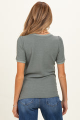 woman wearing a light green short sleeve maternity top with puffed sleeves viewed from the back