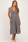 woman wearing a black and white gingham print maternity dress with a v-neck and pockets