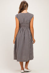 woman wearing a black and white gingham maternity dress with a smocked back detail