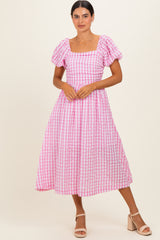 woman wearing a pink and white gingham midi dress with puff sleeves and a square neckline
