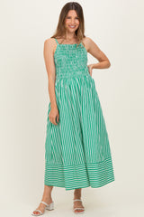 woman wearing a green and white striped maternity maxi dress with smocked bodice and wide hem