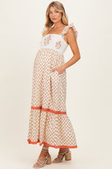 woman wearing a floral print maternity maxi dress with ruffle straps and a visible baby bump