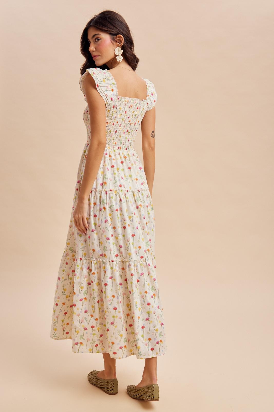 woman wearing a floral print maxi dress with puff sleeves and tiered hem, viewed from the back