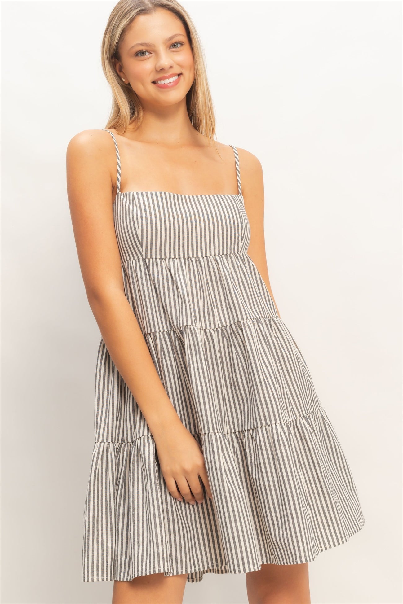 woman wearing a striped tiered sundress with spaghetti straps and a relaxed fit
