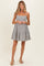 woman wearing a black and white striped maternity dress with a tiered skirt and spaghetti straps